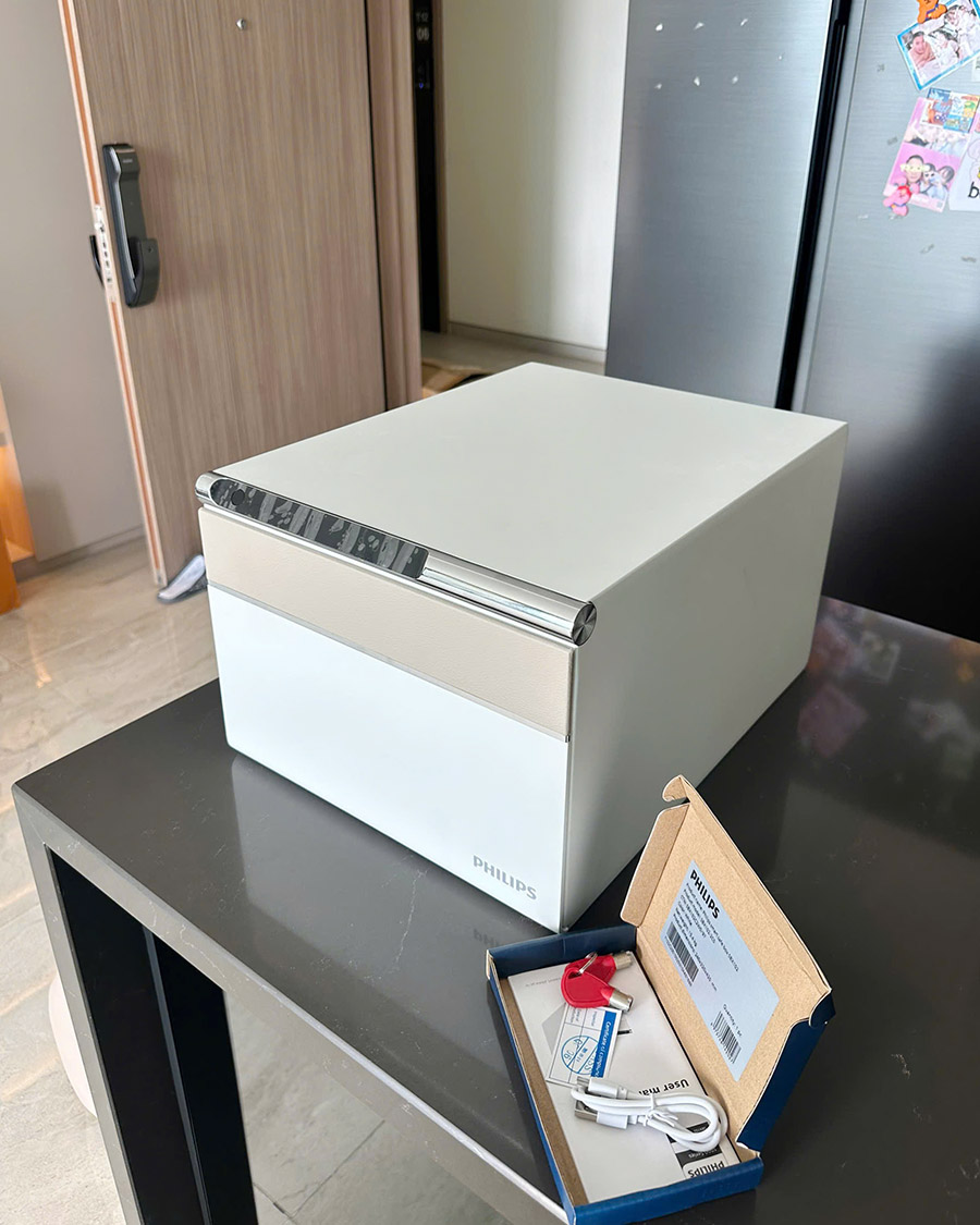 Bản màu trắng đặt cạnh hộp phụ kiện gồm chìa cơ khí và cáp sạc